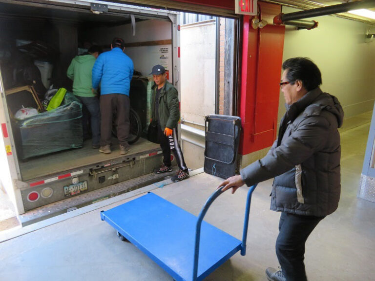 customers unloading a moving truck with items to be stored in a storage unit